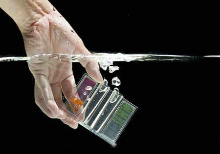 Swimming pool water testing kit dipping in clear water with dark backgroundの写真素材