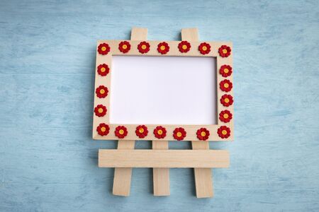 Wooden frame and red paper flower with space on white background and blue wood background