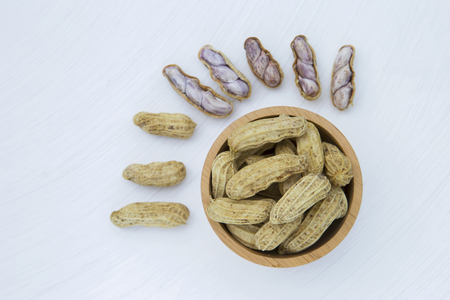 Peanut in the wooden bowl on white background