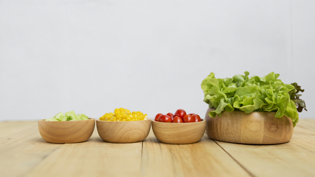 Fresh vegetables in wooden bowl with space on backgroundの写真素材