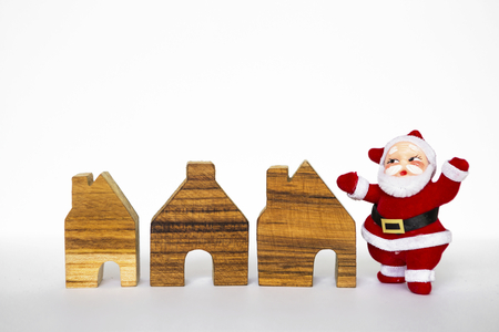 Santa clause and mini wooden house on white backgroundの写真素材
