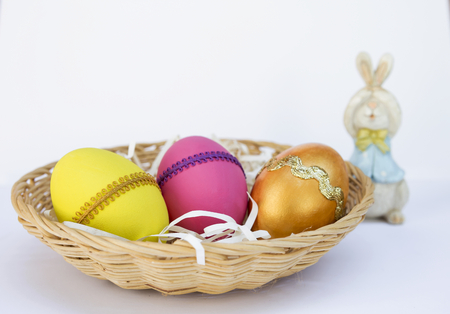 Colorful Easter egg design and blurred Easter bunny on white background