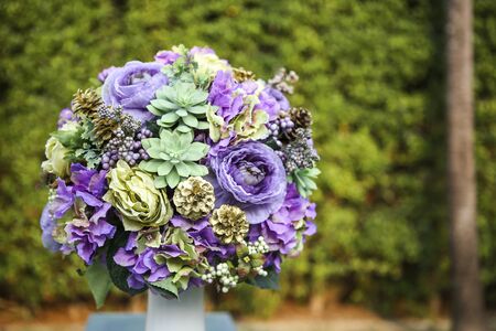 Beautiful flower arrangement over blurred green garden backgroundの写真素材