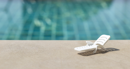 White beach chair over swimming pool background, sunny summer outdoor day lightの写真素材
