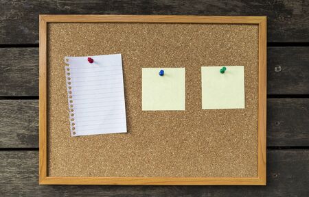 Cork board with wooden frame and blank notepadの写真素材