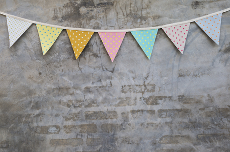 Colorful party flag over cement wall texture backgroundの写真素材