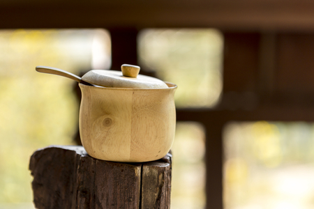 Wooden sugar bowl over blurred window backgroundの写真素材