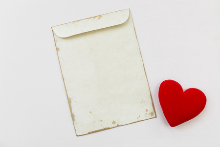 Blank old envelope with red heart on white background, valentine conceptの写真素材