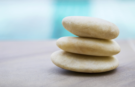 Closeup white natural white zen stone over blurred swimming pool backgroundの写真素材