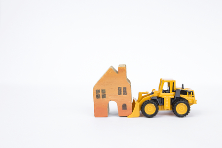 Front loader truck moving wooden miniature house isolate on white background, real estate and...