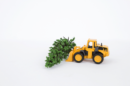 Yellow front loader truck with green tree isolate on white background, Christmas tree and child car toyの写真素材