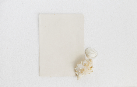 Paper card on white sand with sea shellの写真素材