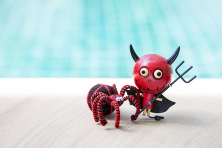 Happy halloween, red devil with black spider over blurred blue backgroundの写真素材