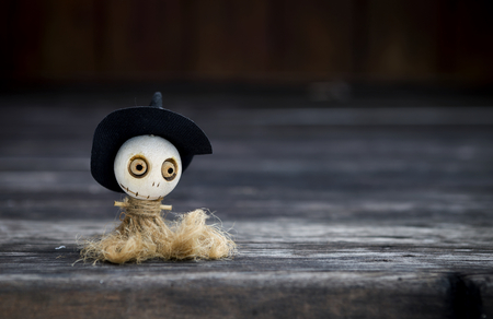 Halloween concept background of wooden witch doll over blurred dark wood backgroundの写真素材
