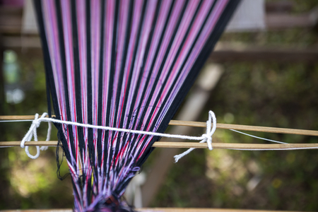 Colorful tread from Thai style wooden weaving loom, traditional Thai style sarong making, outdoor day lightの写真素材
