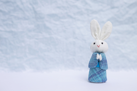 Rabbit doll in Japanese blue dress over blurred background, Japanese style fabric rabbit doll in traditional dressの写真素材