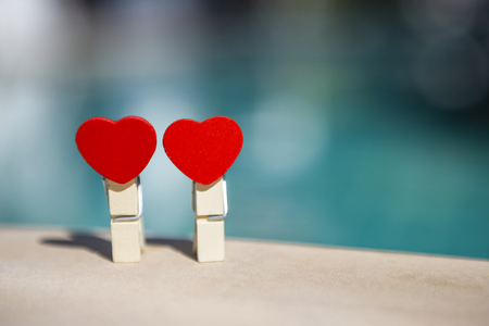 Two wooden red heart clip over blurred blue background, valentine concept background, outdoor day lightの写真素材