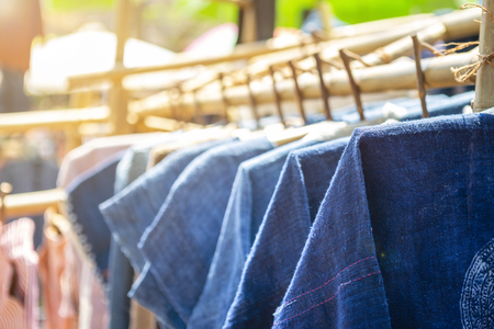 Blue cotton shirt haning on the bamboo rail, outday day light, shopping and fashion concept, Thai style blue cotton shirtの写真素材