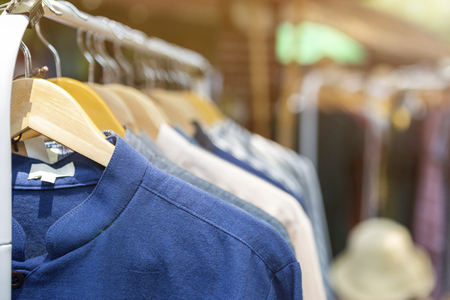 Male shirt hanging on the rail at outdoor market, male fashion, outdoor day lightの写真素材
