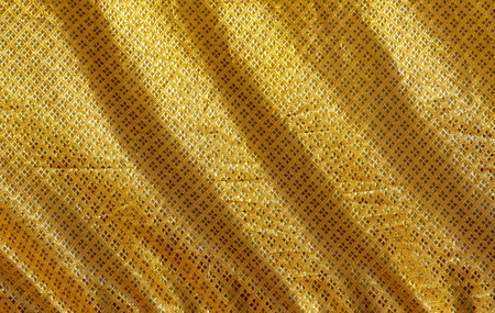 Closeup shiny gold pattern fabric background, blank waving gold fabric backgroundの写真素材