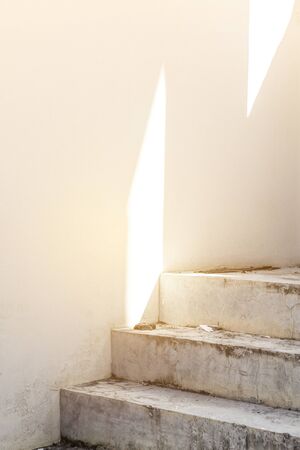 Morning light on the wall, empty white wall and cement stair case, architecture concept backgroundの写真素材