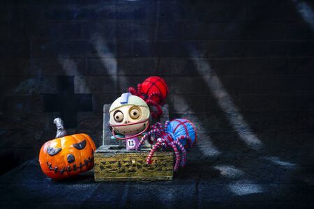 Halloween concept background, little wooden ghost in wooden treasure box with color yarn spider and...