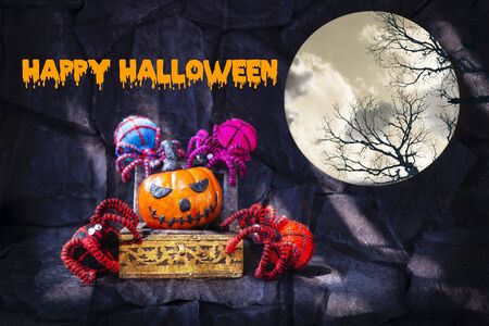 Happy Halloween concept background, Halloween pumpkin in wooden treasure box with group of colourful yarn spider, decorate itemの写真素材