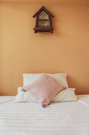 Bed room design idea, wooden vintage style clock on orange wall, interior designの写真素材