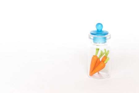 Carrot in the glass jar isolate on white background, small craft carrot in bottleの写真素材