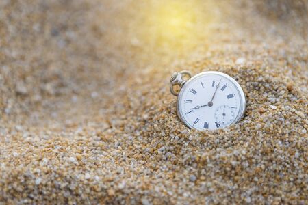 Vintage watch on sand with vintage warm light, time and sand, ancient watch on sand hillの写真素材