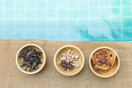 Variety of spice and herbs in wooden bowl with space on blue water background, tea and spice with dry fruit, healthy foodの写真素材