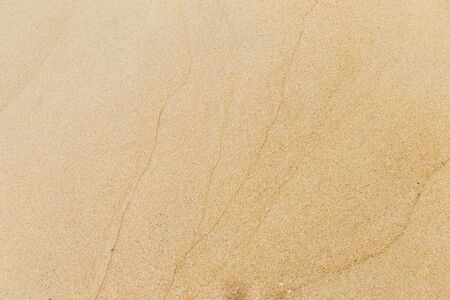 Natural brown sand texture background, wave pattern on sand beach, outdoor day light