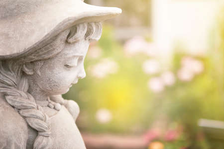 Girl sculpture over blurred garden background, spring season, garden decoration, outdoor day lightの写真素材