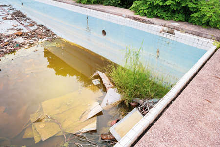 Garbage in abandoned pool, dangerous area, water pollutionの写真素材