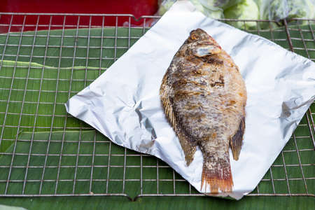 Grilled river fish at the outdoor fresh market in Northern Thailand, Thai style fish cover with salt...