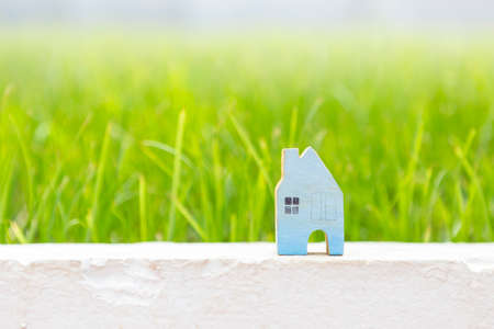Blue wooden house over blurred beautiful green grass background, outdoor day light, house loan or property business concept, new houseの写真素材