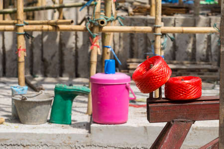 Red plastic rope roll on steel bar over blurred construction site, outdoor day lightの写真素材