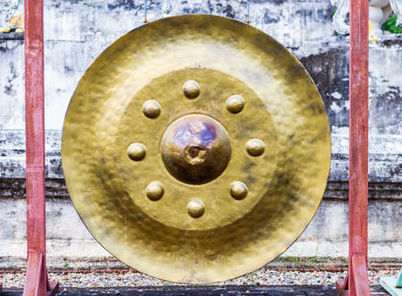Traditional northern Thai style gold color gong hanging at the temple in Thailandの写真素材