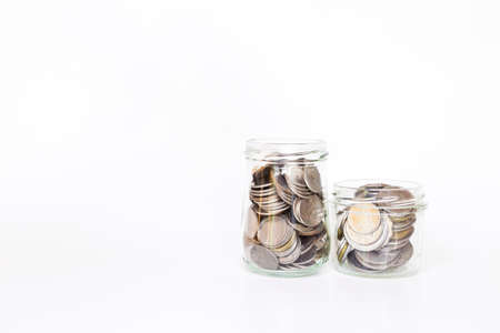 Glass bottles full of coin on white background, saving money, financial and banking conceptの写真素材