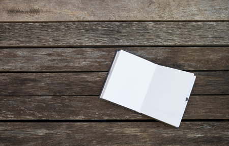 Blank white notebook on old wooden floor background, education concept