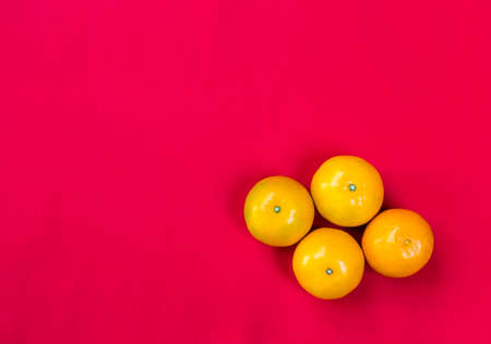 Fresh orange fruit on red fabric background, simple Chinese new year concept backgroundの写真素材