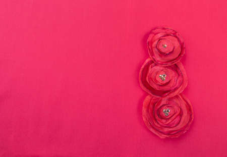 Red fabric flower on red background, Valentine background idea, handmade fabric rose flower with space on red fabric texture backgroundの写真素材