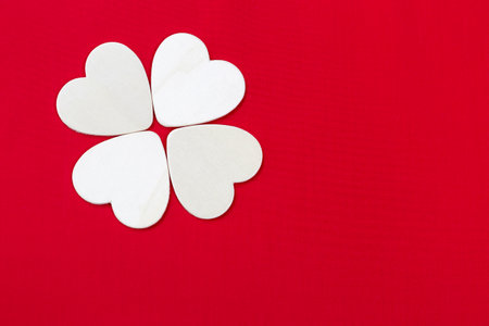 White wooden heart arrange in flower shape on red fabric background, valentine card background ideaの写真素材
