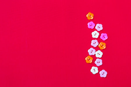 Flower plastic button on red fabric background, valentine card background idea