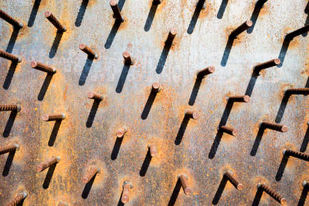 Rusty steel bar on old steel wall background, exterior design background, outdoor day light