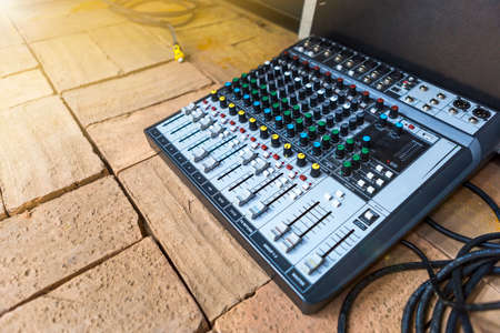 Sound control board on brink floor with vintage warm light, sound technology, controls of audio...