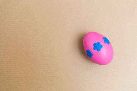 Pink egg decorate with blue papper flower on brow paper background, Easter concept backgroundの写真素材