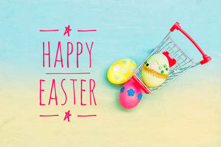 Happy easter card background idea, Colorful easter egg decorate with paper flower in shopping cart with space on blue texture backgroundの写真素材