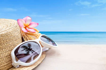 Summer concept background, women sunglass with jute hat over blurred beach background, outdoor day lightの写真素材