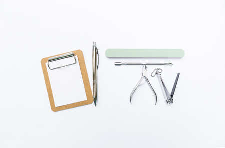 Basic nail tool kit with paper clipboard and silver pen isolate on white background, manicure...